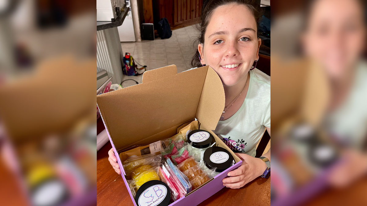 Shamira Martinez a young woman holding a purple box with packaged beauty products